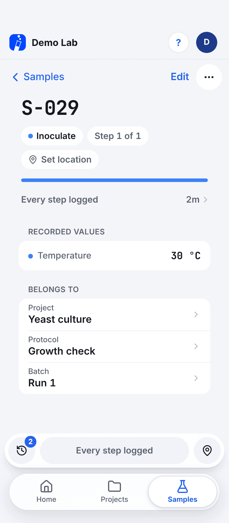 The record of sample S-029: the step Inoculate, step 1 of 1, Every step logged, the recorded value Temperature 30 °C, and what it belongs to: project Yeast culture, protocol Growth check and batch Run 1. A history button at the bottom shows 2 entries.
